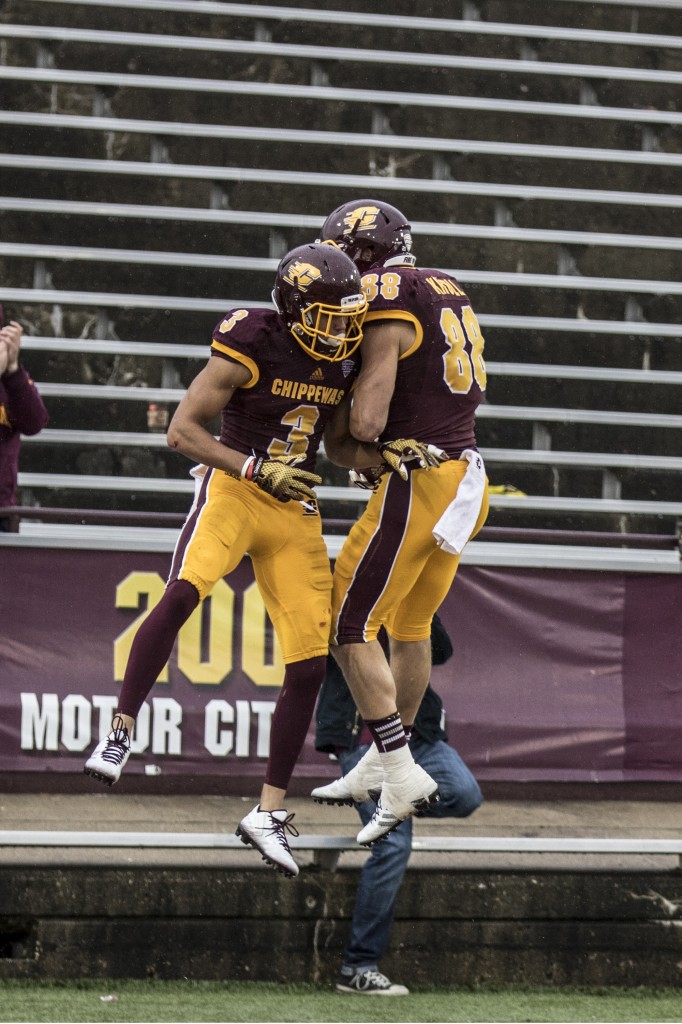 Mark Chapman, 3, celebrates with Jesse Kroll, 88, after Kroll scores a touchdown during the football game against Northern Illinois University on the campus of Central Michigan University, Mt. Pleasant, MI, Sunday, October 3, 2015.