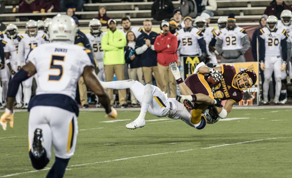 Jesse Kroll, 88, is tackled during the game against the University of Toledo at Kelly Shorts Stadium, on the campus of Central Michigan University, Mt. Pleasant, Michigan, Tuesday, November 10, 2015.
