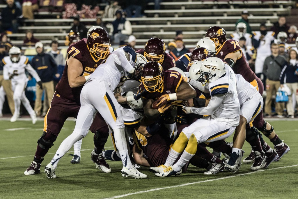 Jahray Hayes, 11, is tackled by a gang of defenders during the game against the University of Toledo at Kelly Shorts Stadium, on the campus of Central Michigan University, Mt. Pleasant, Michigan, Tuesday, November 10, 2015.